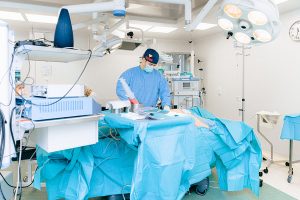 A surgeon doing a surgical procedure in an operating room.