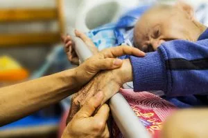 An elderly held by a family member during a visit in nursing home.