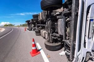 Un camión tumbado de lado tras un accidente de tráfico.