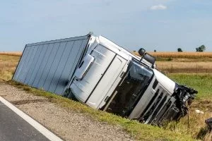 Truck lies in a side after road accident.